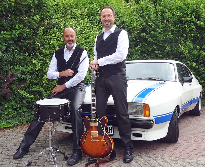 Alles Essex auf diesem Bild: Malcom Beresford und Frank Wilhelm vor dem Capri-Typ, der Auslöser für den Song „Querlenker Blues“ war. Alles Essex auf diesem Bild: Malcom Beresford und Frank Wilhelm vor dem Capri-Typ, der Auslöser für den Song „Querlenker Blues“ war.