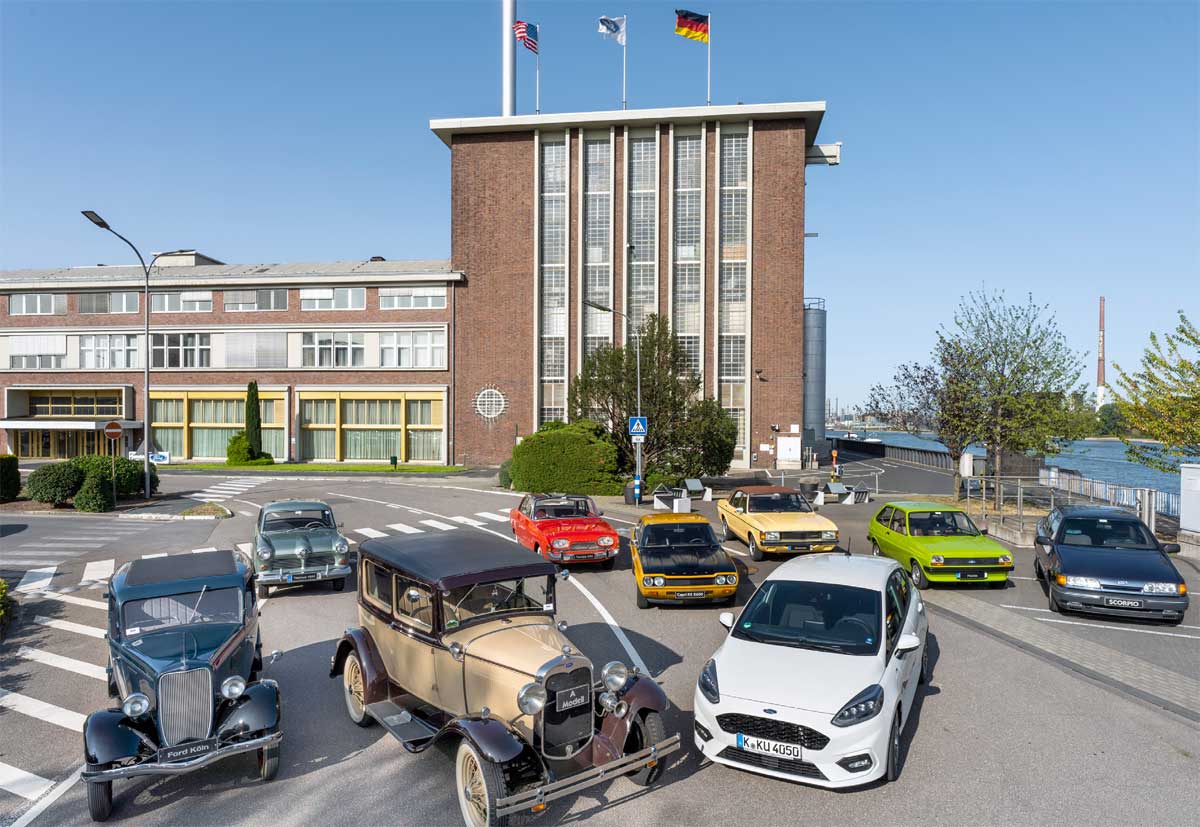 Der Kölner Dauerbrenner und sein Urahn: Das Modell A (vorn in der Mitte) ist die erste Pkw-Baureihe, die Ford in Köln produziert hat. Der Fiesta EcoBoost Hybrid aus der aktuellen, achten Fiesta-Generation, ist die erste elektrifizierte Variante des Kleinwagens. Drumherum verschiedene Modelle aus rheinischer Produktion. Alles vor der Halle A, deren Grundstein Henry Ford und Konrad Adenauer am 2. Oktober 1930 legten. Der Kölner Dauerbrenner und sein Urahn: Das Modell A (vorn in der Mitte) ist die erste Pkw-Baureihe, die Ford in Köln produziert hat. Der Fiesta EcoBoost Hybrid aus der aktuellen, achten Fiesta-Generation, ist die erste elektrifizierte Variante des Kleinwagens. Drumherum verschiedene Modelle aus rheinischer Produktion. Alles vor der Halle A, deren Grundstein Henry Ford und Konrad Adenauer am 2. Oktober 1930 legten.