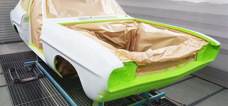 Die zuvor geschweißte und blank geschliffene Karosse in der Lackiererei. Die zuvor geschweißte und blank geschliffene Karosse in der Lackiererei.